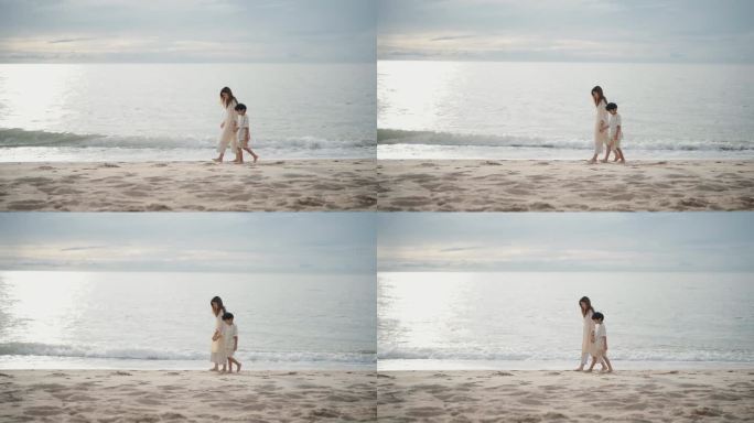 愉快的母亲和她的儿子在度假期间在海滩上散步。