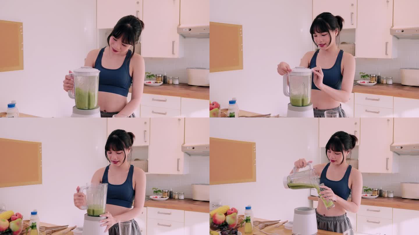 一位穿着运动服的快乐的亚洲妇女将水果和蔬菜混合在一起，在她的厨房里品尝着营养丰富的冰沙。她崇尚健康快