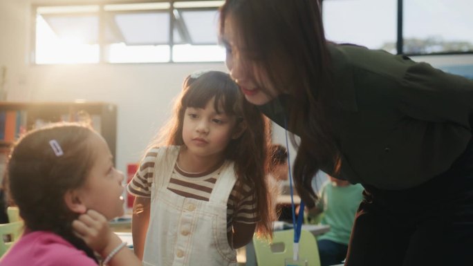 一位漂亮的女老师正在教室里和小学生们交谈。