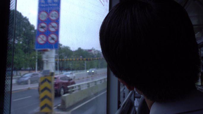 公交车上中老年人望向车窗外