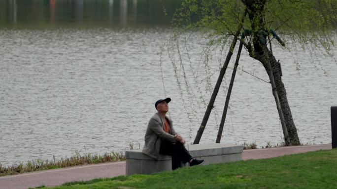 公园河边坐着发呆的老人