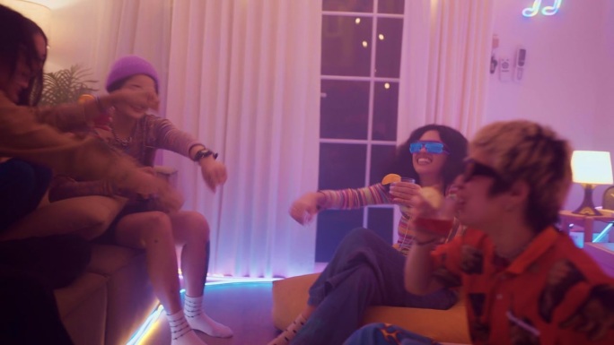 一群快乐的朋友坐在沙发上唱歌跳舞，一起喝啤酒。