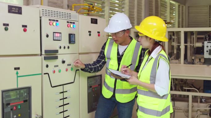 在工业工厂检查开关柜配电变电站状态的工程师和技术工人。电气工程师。