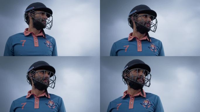 一名南亚板球运动员身穿蓝色制服，头戴头盔站在球场上的低角度肖像。印度职业运动员在大型国际比赛前注视镜
