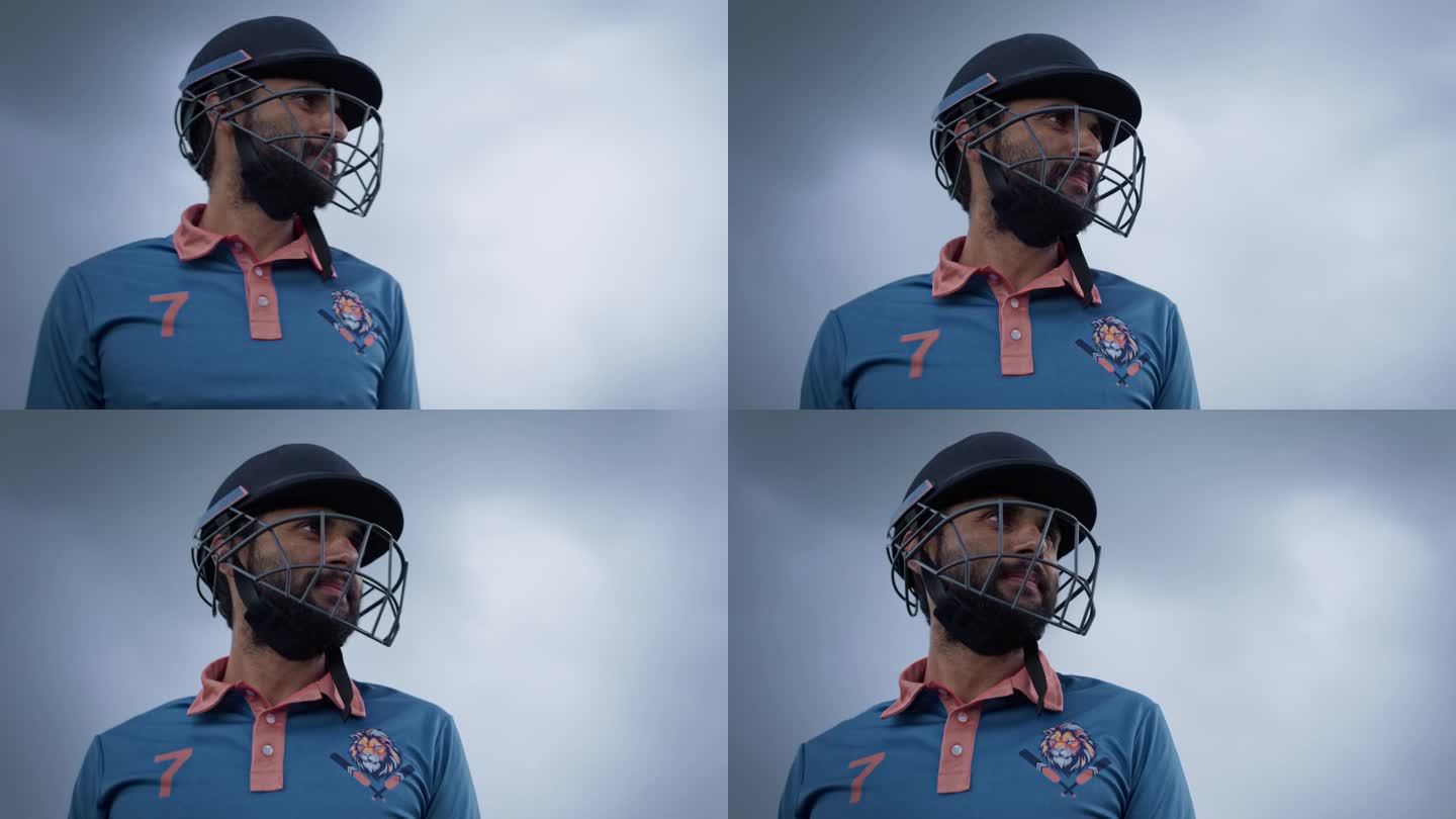 一名南亚板球运动员身穿蓝色制服，头戴头盔站在球场上的低角度肖像。印度职业运动员在大型国际比赛前注视镜