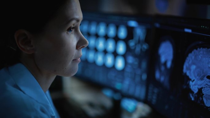 医院研究实验室:用计算机与脑扫描核磁共振成像近距离观察女医学家。专业神经学家分析实时CT扫描诊断病人