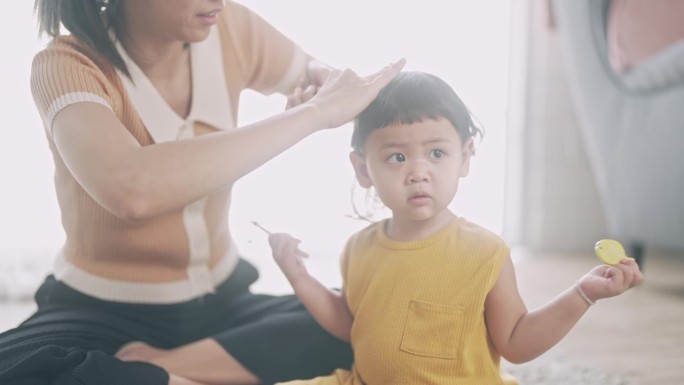 妈妈在给女儿梳头温馨时刻爱意浓浓满溢