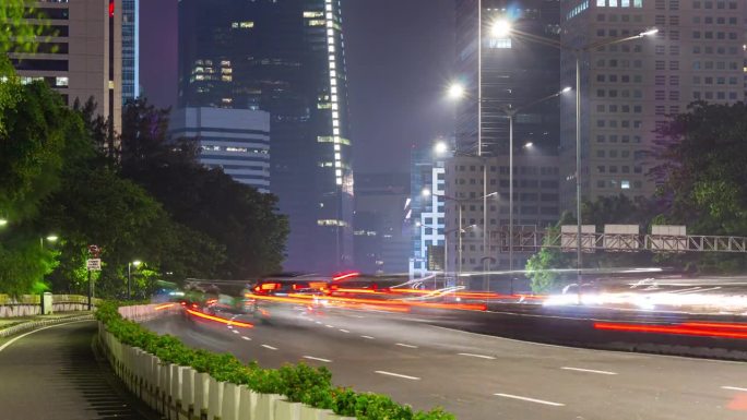 夜晚照亮雅加达市中心的交通街道道路侧面全景4k延时印尼