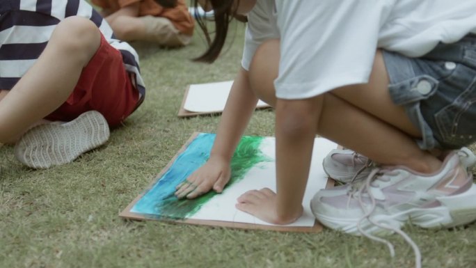 年轻的亚洲女孩用水彩书写和绘画，喜欢户外活动，在学校操场上玩耍和学习。