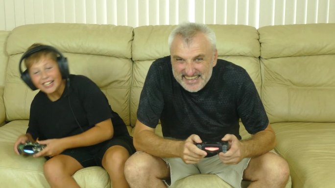 父子俩在沙发上玩电子游戏