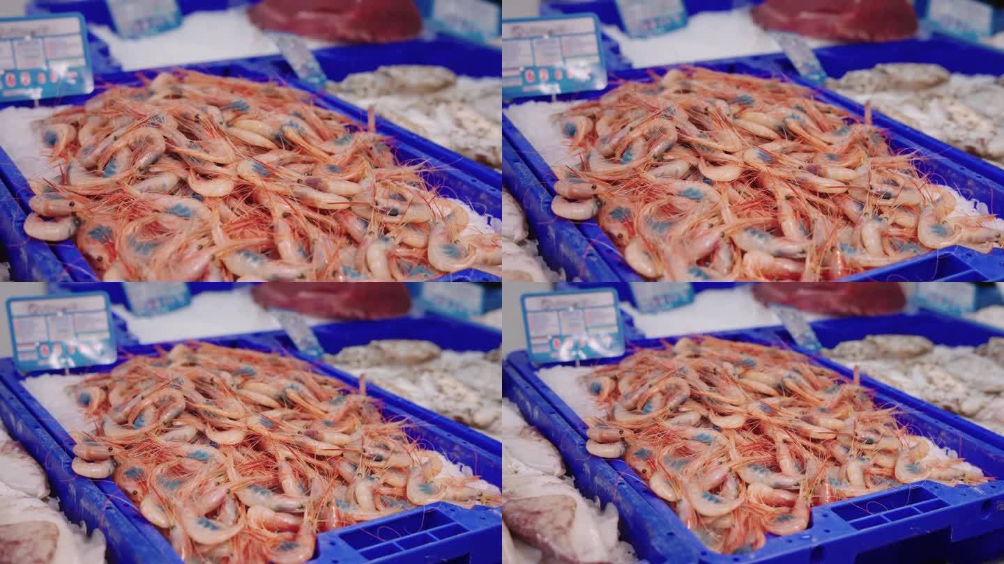在当地一家鱼贩的商店里，把镜头拉近几箱带鱼子的对虾和其他鱼