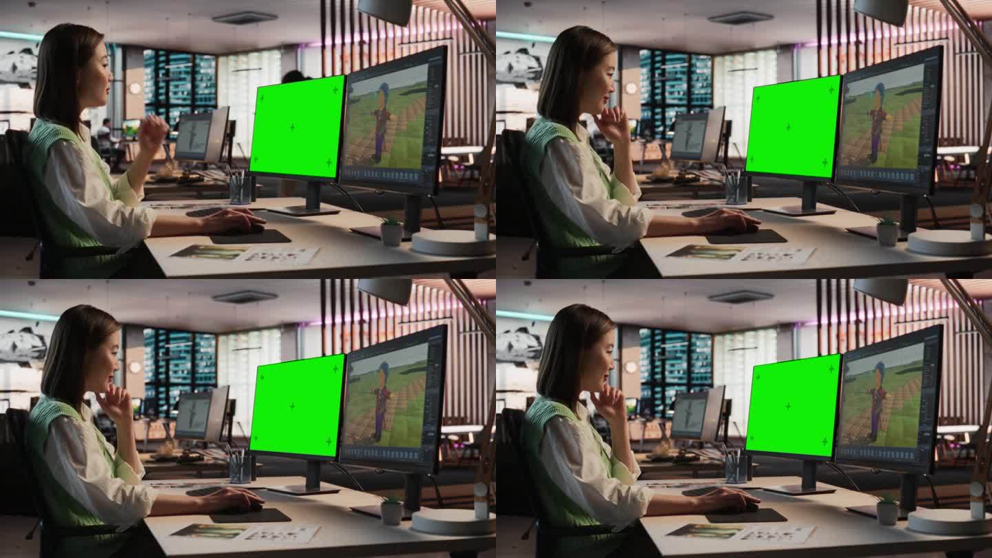 亚洲女游戏设计师使用桌面电脑绿屏Chromakey显示，设计角色在3D建模软件的生存视频游戏。在游戏