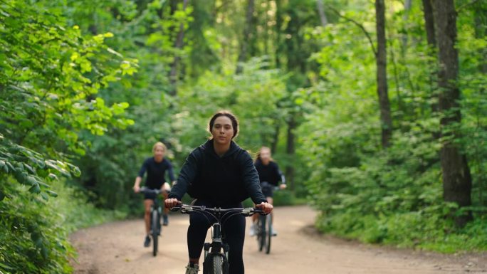 夏天，少女或大学生在森林里骑自行车，在大自然中度过愉快的周末