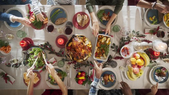 各种各样的亲戚和朋友围坐在餐桌后面，享用美味的饭菜和节日的装饰。人们分享食物，交谈，创造欢乐的节日气