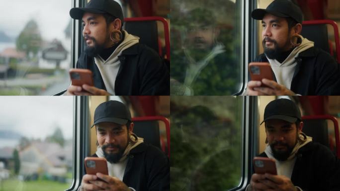 一个开朗的亚洲人在火车上用手机阅读和聊天。
