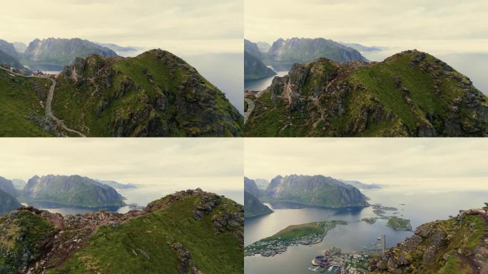 无人机飞过雄伟的绿色岩石峡湾，飞向水上的北欧渔村