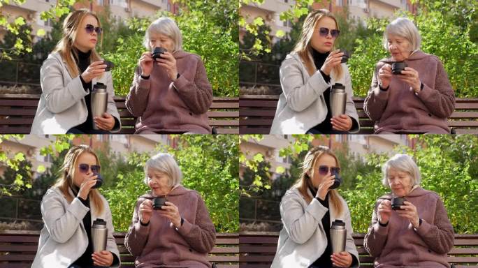 一位成年妇女和一位年老的祖母坐在公园的长椅上喝茶。