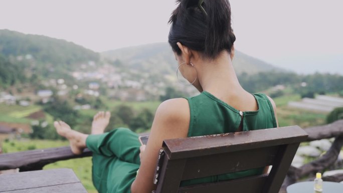 亚洲女性用智能手机在山间自然中工作和拍照。