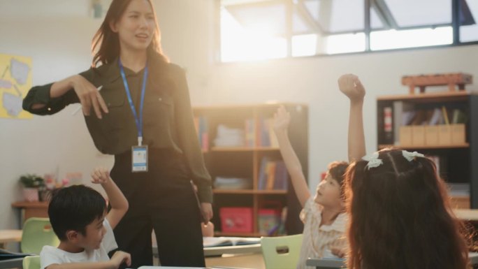 在教室里，一群快乐的小学生举起手臂回答一位漂亮的女老师的问题。