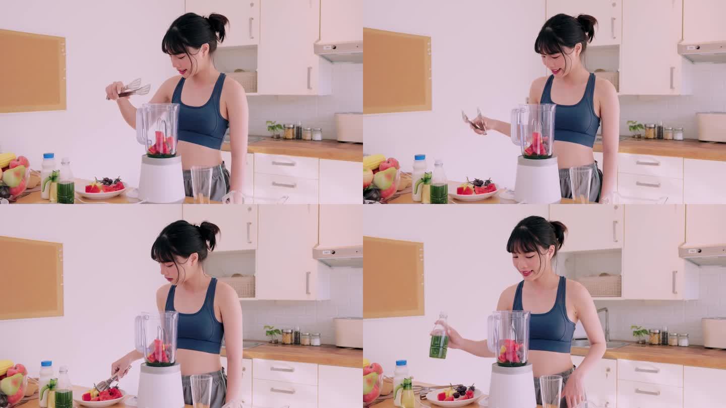 一位穿着运动服的快乐的亚洲妇女将水果和蔬菜混合在一起，在她的厨房里品尝着营养丰富的冰沙。她崇尚健康快