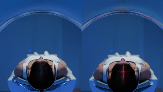 垂直屏幕:在医学实验室，躺在CT或MRI扫描床上的匿名女性患者的镜头正在接受红色激光的扫描程序。床向