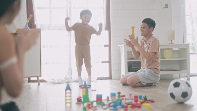 亚洲男孩踢球和破坏玩具木块。和家人一起玩