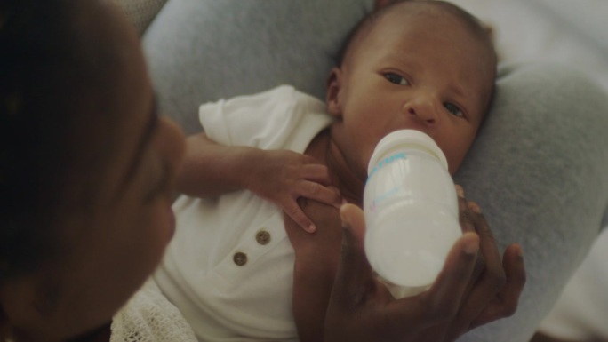 婴儿从奶瓶里喝牛奶