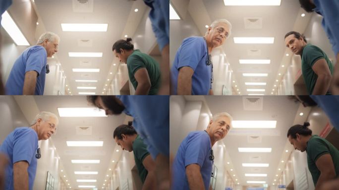 一组医学专家用担架运送病人通过医院走廊的慢动作POV。保健诊所接收重症监护室急诊病例