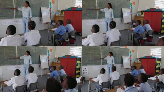 特写镜头。非洲黑人女教师站在黑板前，在非洲的一间教室里给孩子们上课