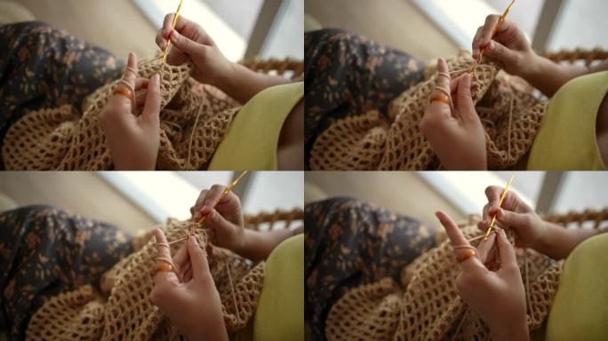 年轻女子在家在公寓里编织。