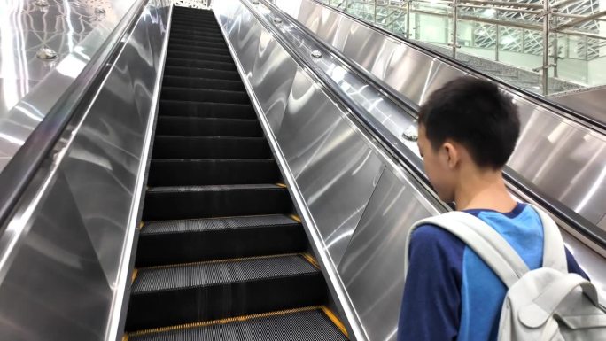 地铁自动扶梯上的男孩
