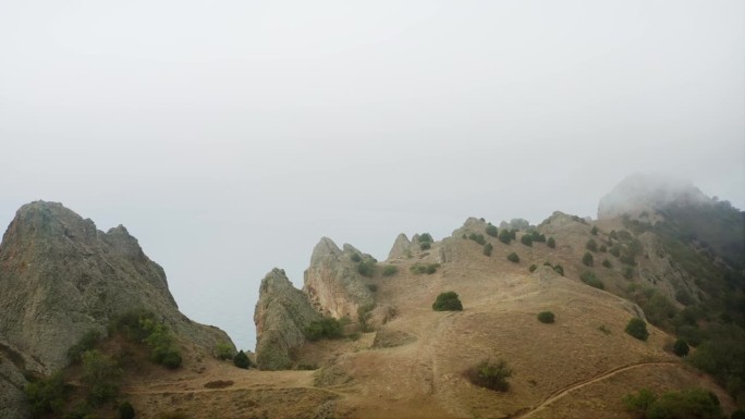 海面上的悬崖，尖锐的岩石和石头，雾气模糊了视线，漫山遍野。无人机航拍。