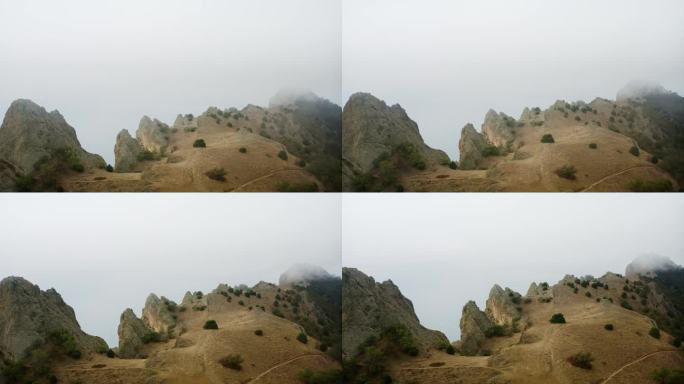海面上的悬崖，尖锐的岩石和石头，雾气模糊了视线，漫山遍野。无人机航拍。
