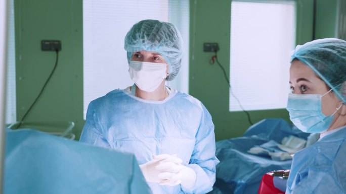 一位经验丰富的资深女外科医生和她熟练的团队在手术室精心准备复杂的手术。信任他们的医疗保健专业知识和奉