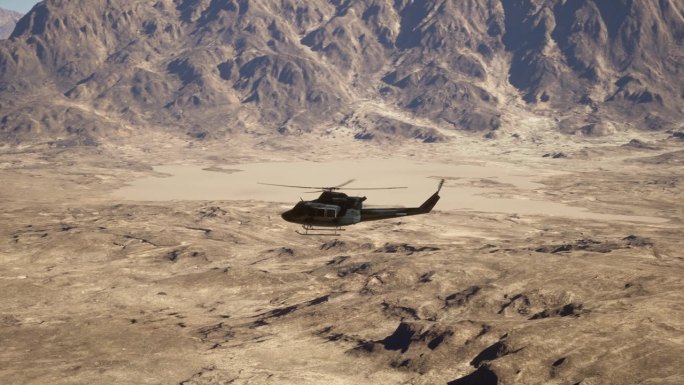 一架直升机飞过沙漠中的山脉
