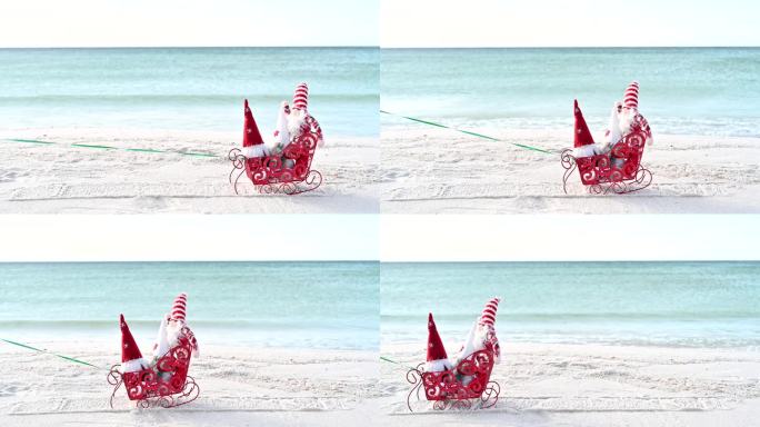 圣诞小精灵在沙滩上的红色雪橇在一个阳光明媚的冬日