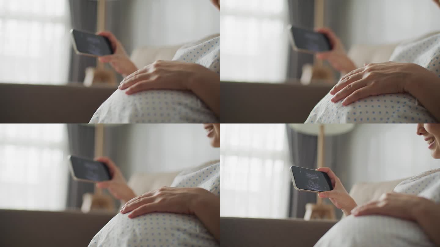 孕妇坐在沙发上看手机上的超声波图片