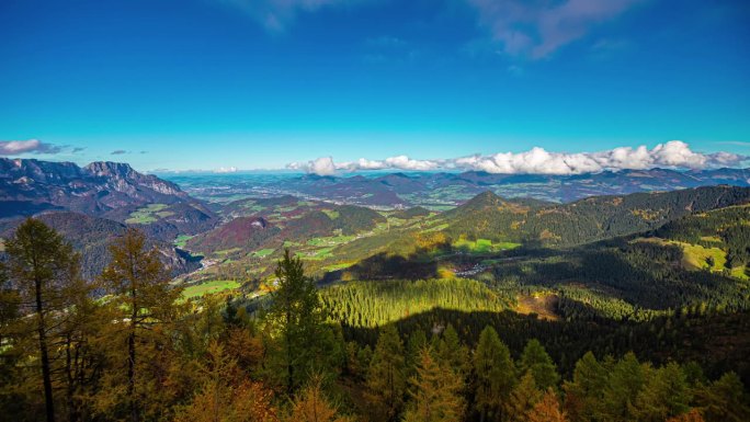 延时拍摄的云在德国贝希特斯加登阿尔卑斯山的秋天色彩的山脉上移动