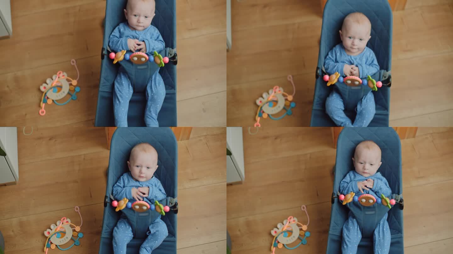 可爱的5个月大的小男孩坐在玩具前的摇椅上摇着自己