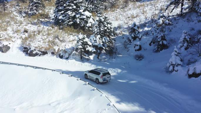 航拍冬天森林雪地山路上行驶的汽车