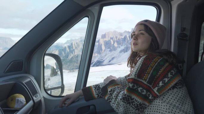 冬天穿着针织毛衣坐在露营车里的女人