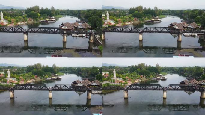 用无人机拍摄的超级可爱的桂河纪念大桥的风景镜头;泰国北碧府，向左边滑动，露出一座寺庙、社区和度假村，