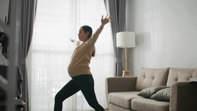 年轻孕妇在家客厅健身