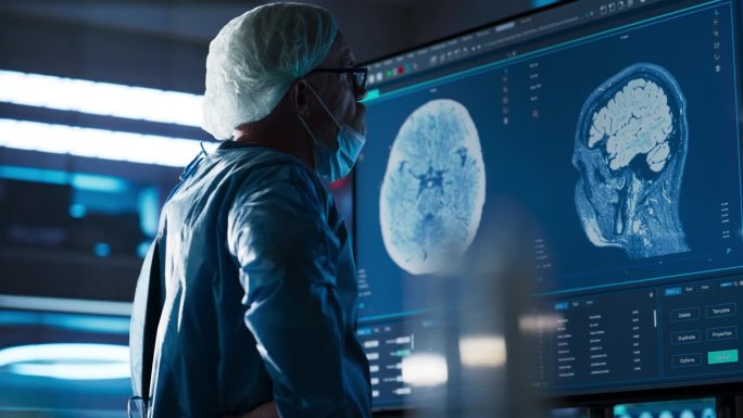 医院研究实验室:白人男性神经外科医生看着电视屏幕，用大脑MRI扫描病人，分析，准备复杂的神经外科手术