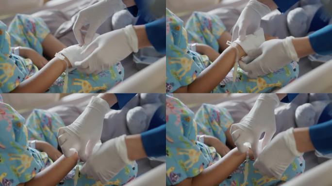 亚洲护士在病房里照顾用布包着的孩子的手。