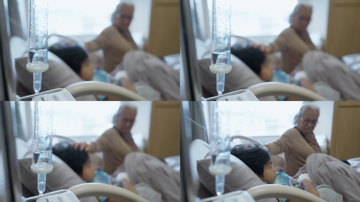 一个小男孩躺在医院的病床上，奶奶抚摸着他的头。她希望他早日康复。