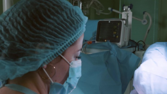 外科医生在手术室里工作，在手术室里有现代化的设备，用于神经外科和整形外科的医疗产品。医生团队进行全身