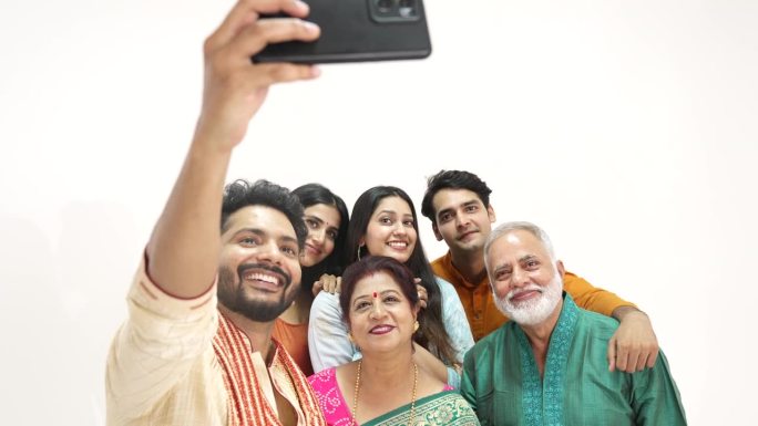 印度幸福的一家人站在一起用手机自拍。