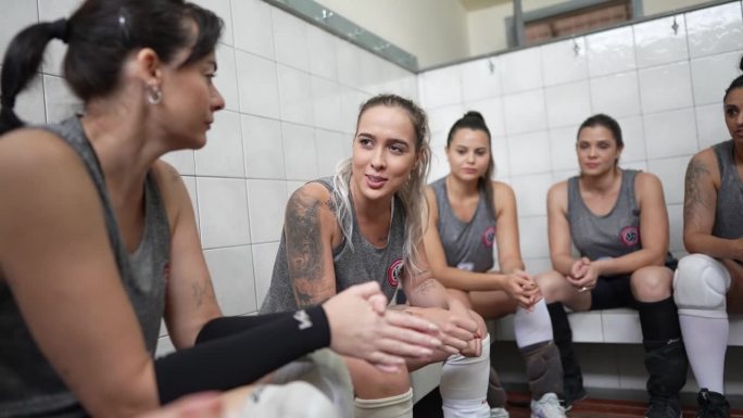 年轻的女球员在更衣室与队友交谈