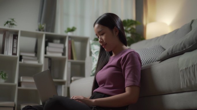 一位年轻的成年女性在半夜用笔记本电脑工作